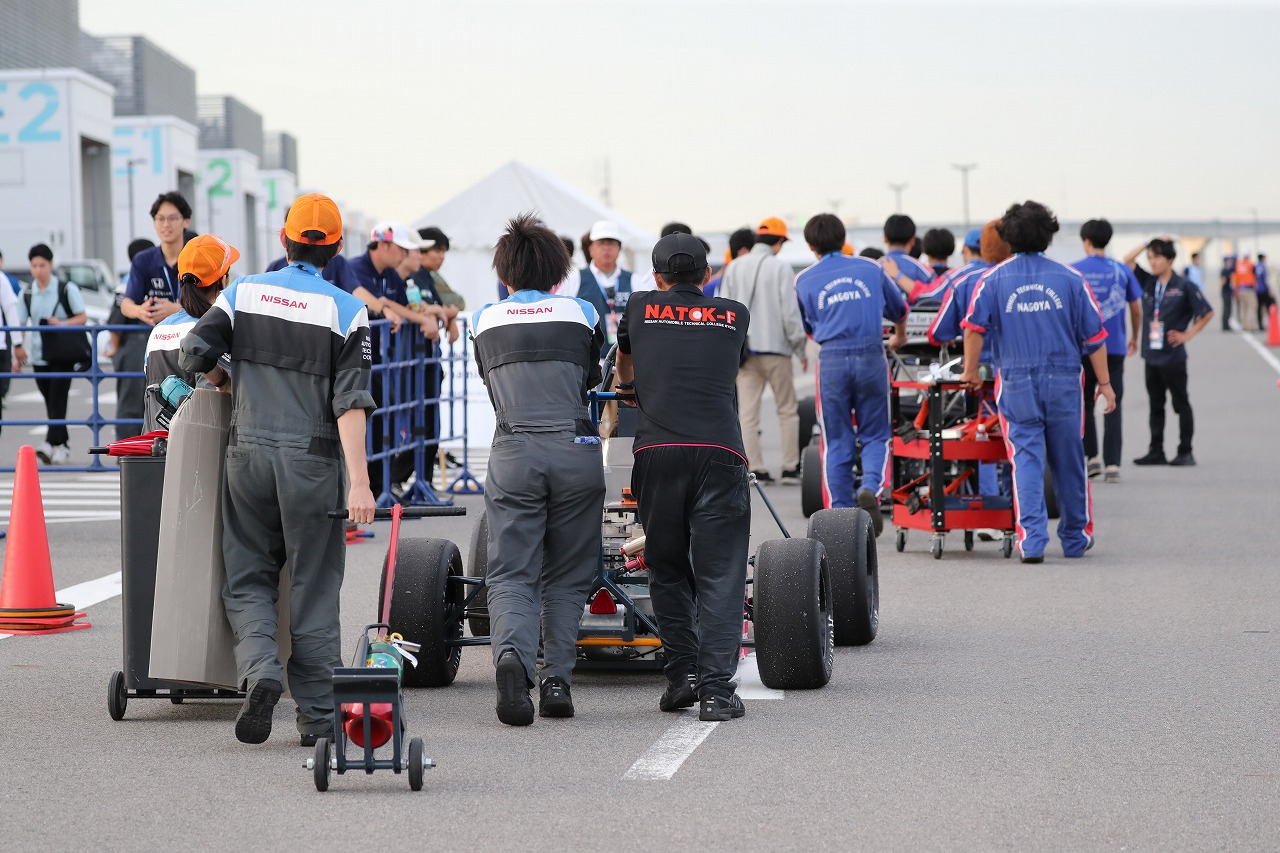 走行待機列へマシンを搬送する各チーム